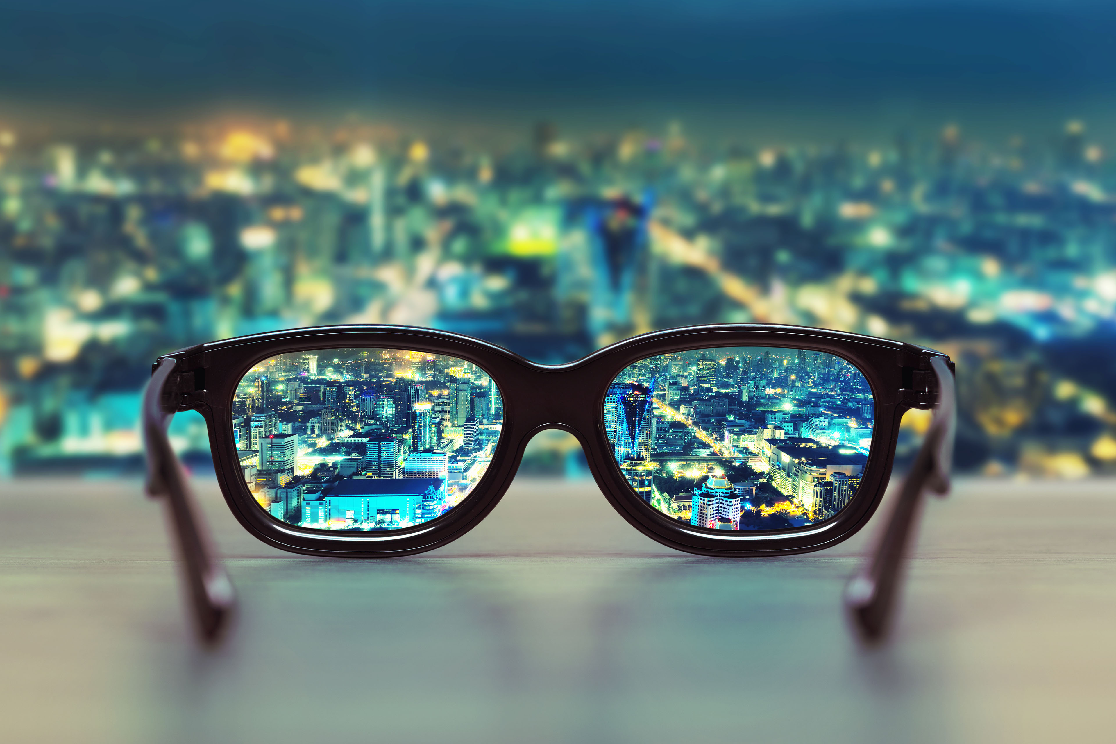 Briller ligger på bord med udsigt ud over byen