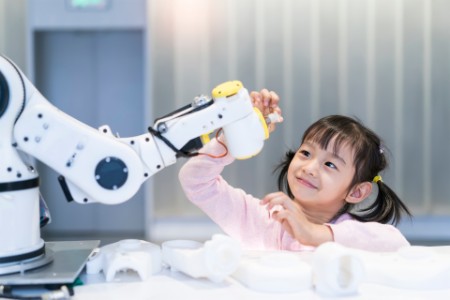 Asian little girl touching robot 