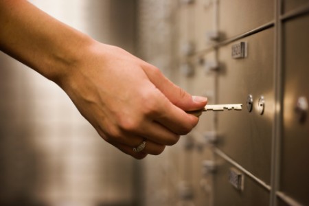 ey hand holding key to safety deposit box