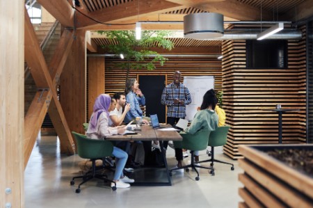 成員多元化的團隊在設計新穎的辦公室內進行會議。